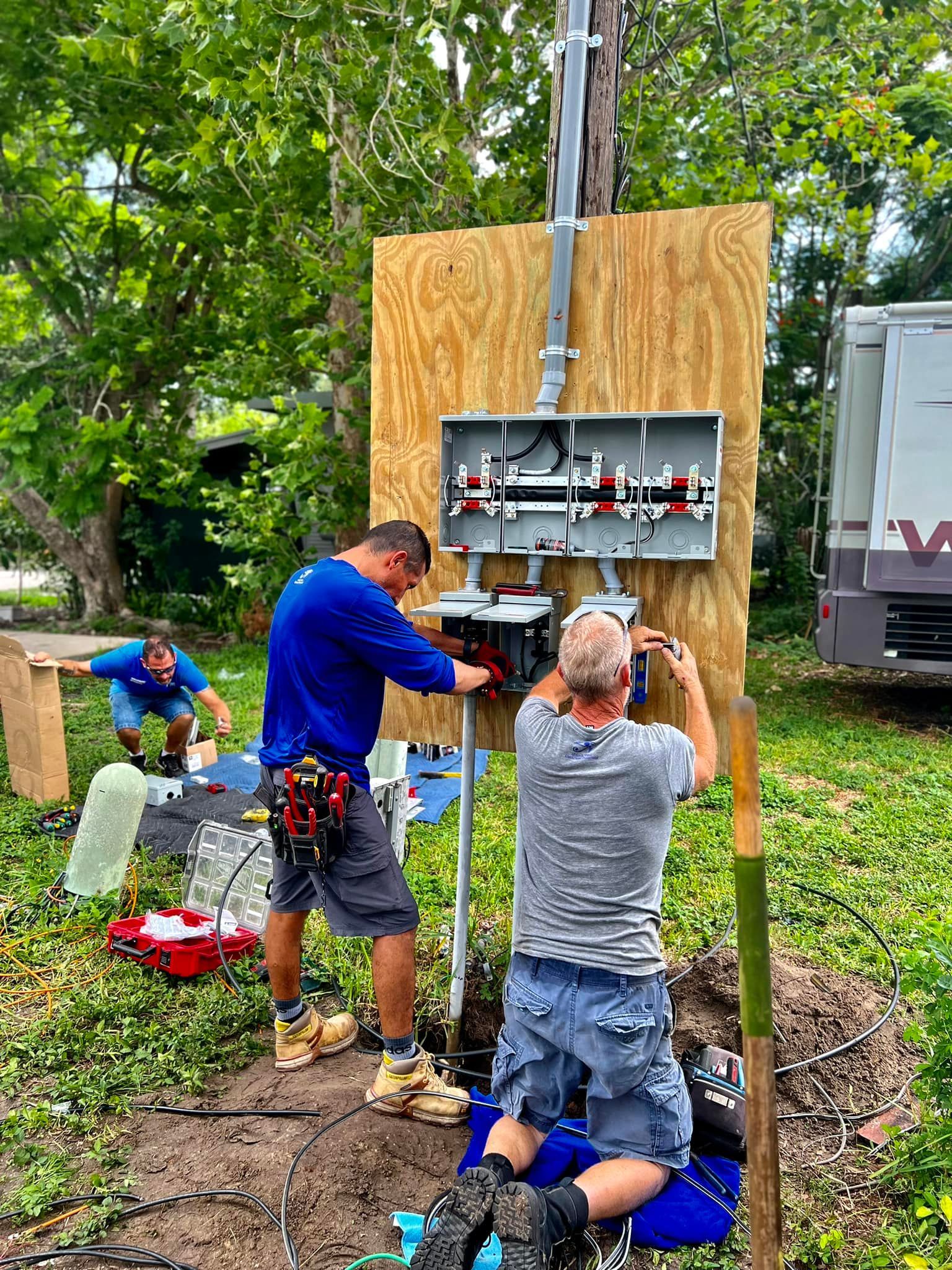 Two Men Are Working on A Power Box in A Yard — Tarpon Springs, FL — Pinellas County Electric