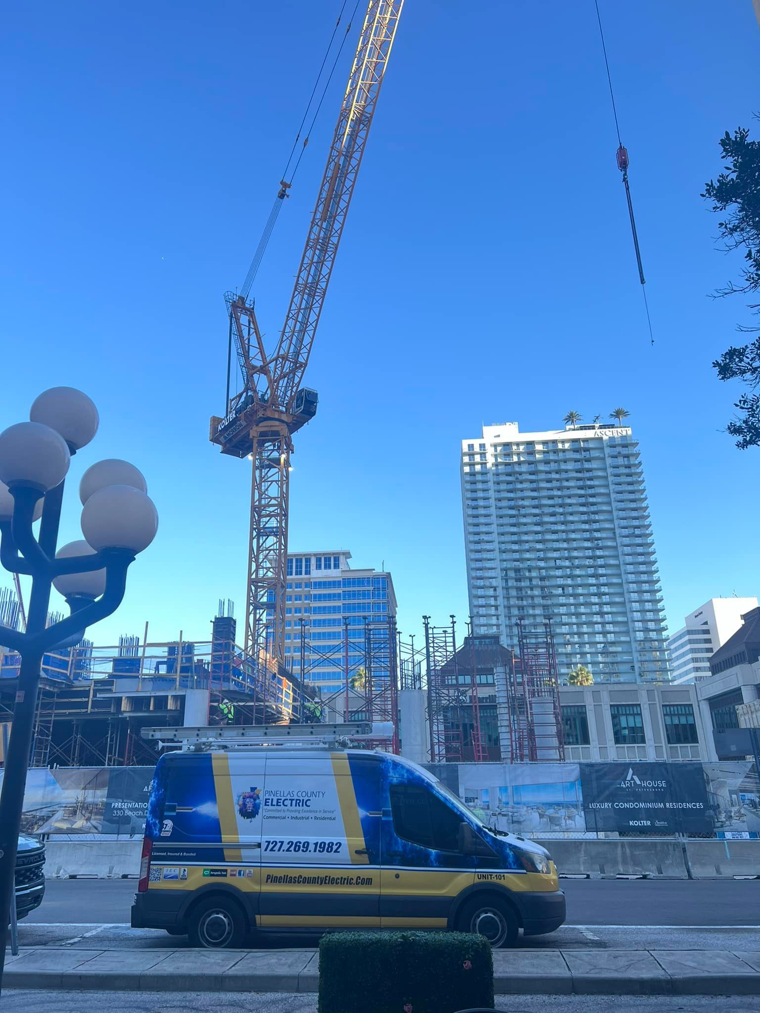 A Van Is Parked in Front of A Construction Site with A Crane in The Background — Tarpon Springs, FL — Pinellas County Electric