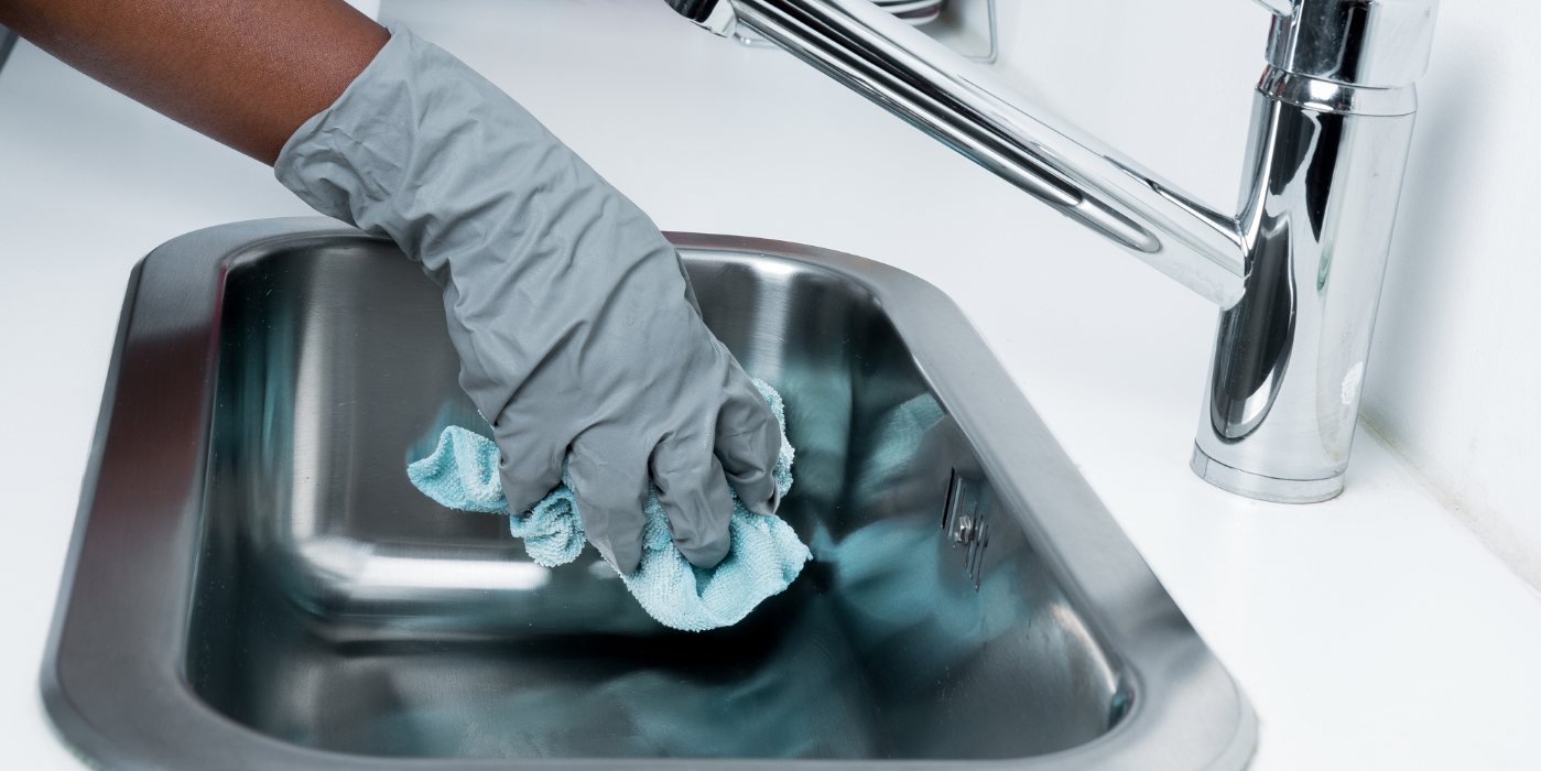 A plumber is fixing a sink with a wrench.