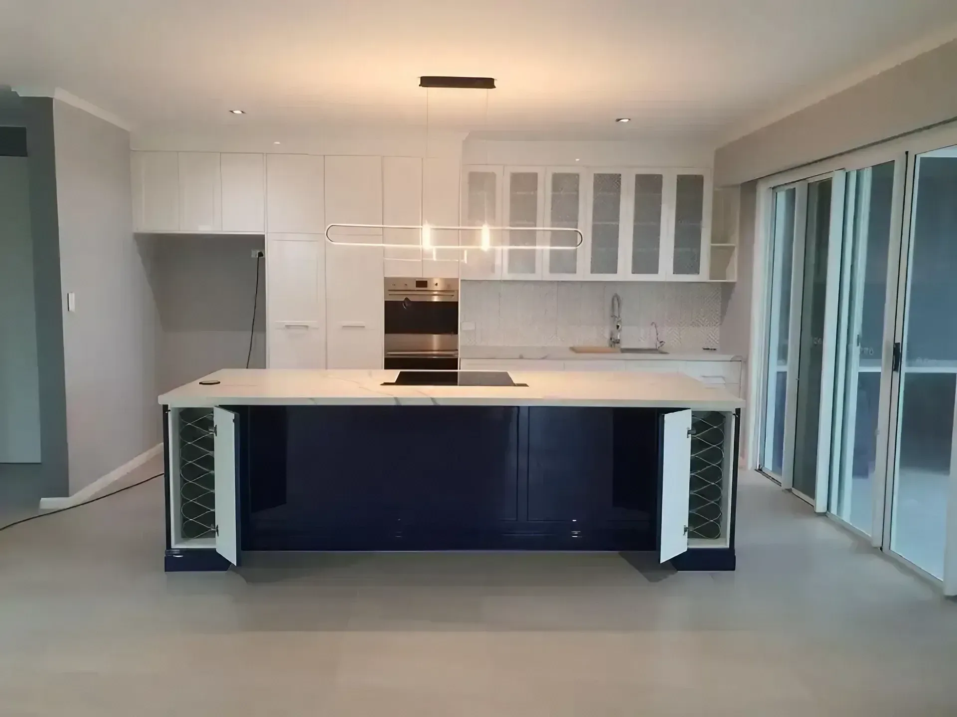 A Kitchen with A Large Island and White Cabinets — JWB Joinery in Aitkenvale, QLD