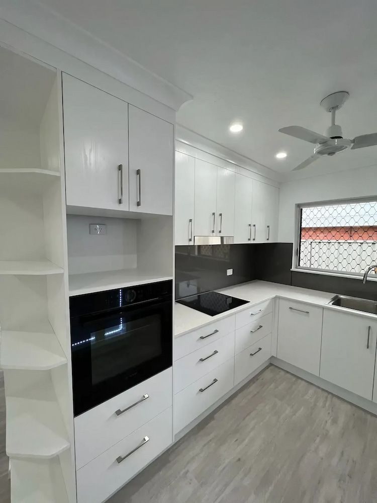 A Kitchen with White Cabinets and A Black Oven — JWB Joinery in Aitkenvale, QLD