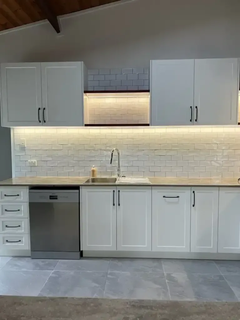 Kitchen with White Cabinets, a Sink, a Dishwasher, and A Brick Wall — JWB Joinery in Aitkenvale, QLD