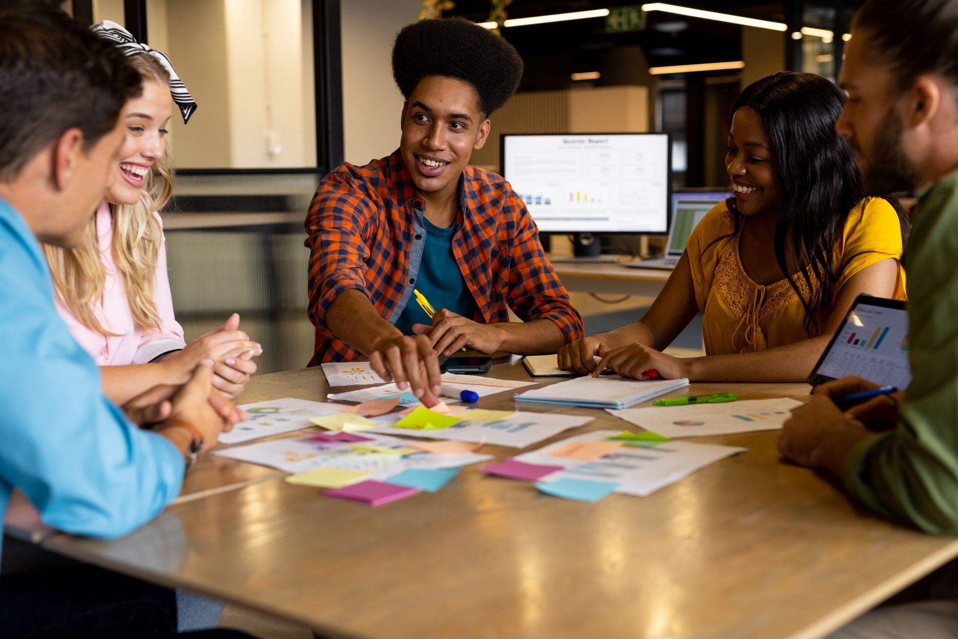 Un groupe de personnes sont assises autour d'une table avec des post-it dessus.