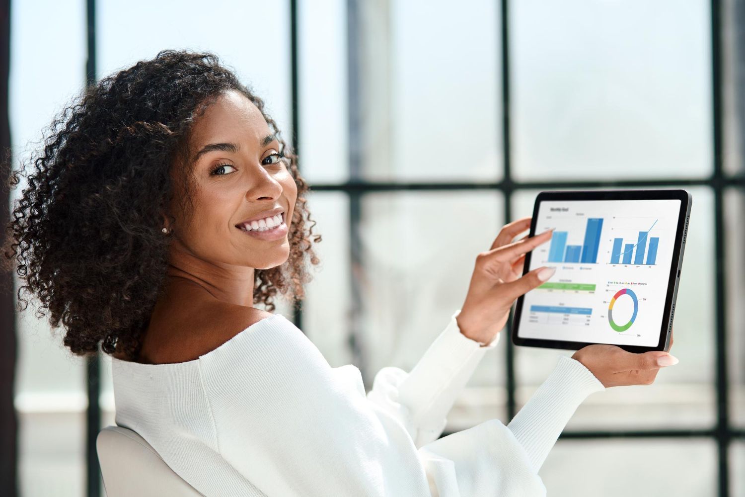 Une femme tient une tablette avec un graphique dessus.