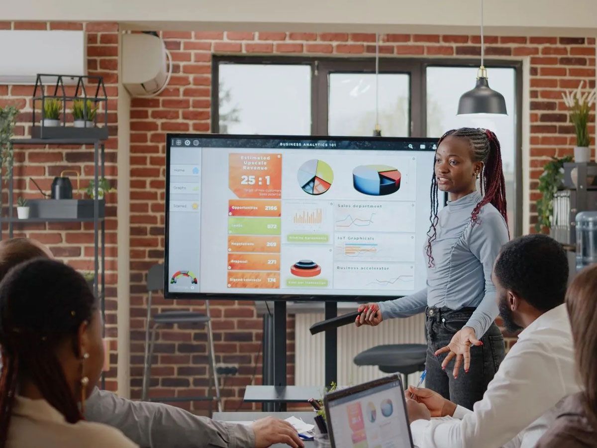 Une femme fait une présentation à un groupe de personnes.