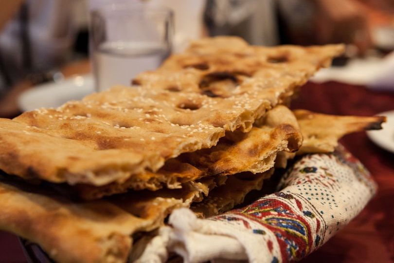 A stack of bread is sitting on top of a napkin on a table.