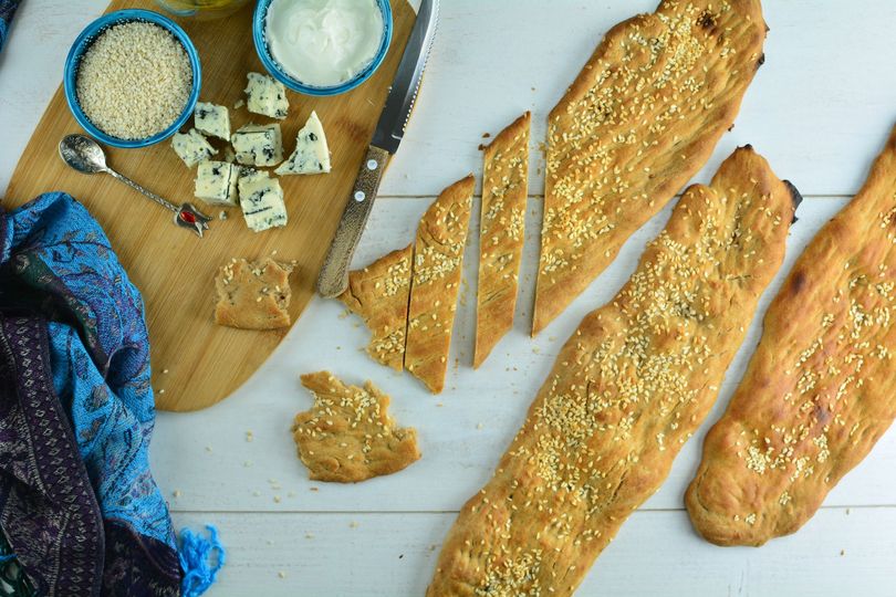 A wooden cutting board with bread and cheese on it