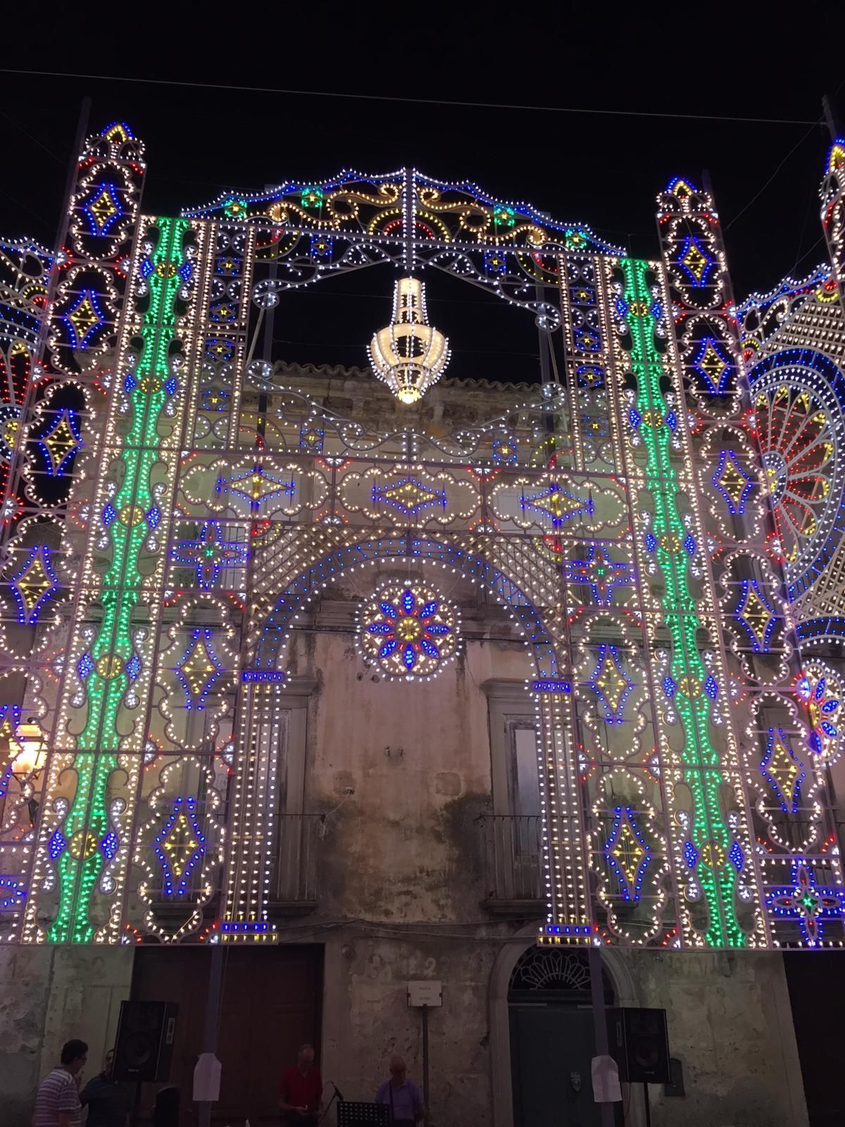 La facciata illuminata dell'edificio, adornata di luci colorate e con una lanterna sospesa di notte.