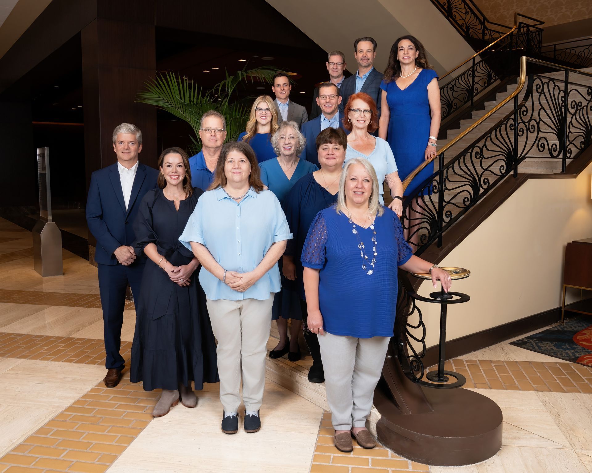 A group of people are posing for a picture in front of a staircase.