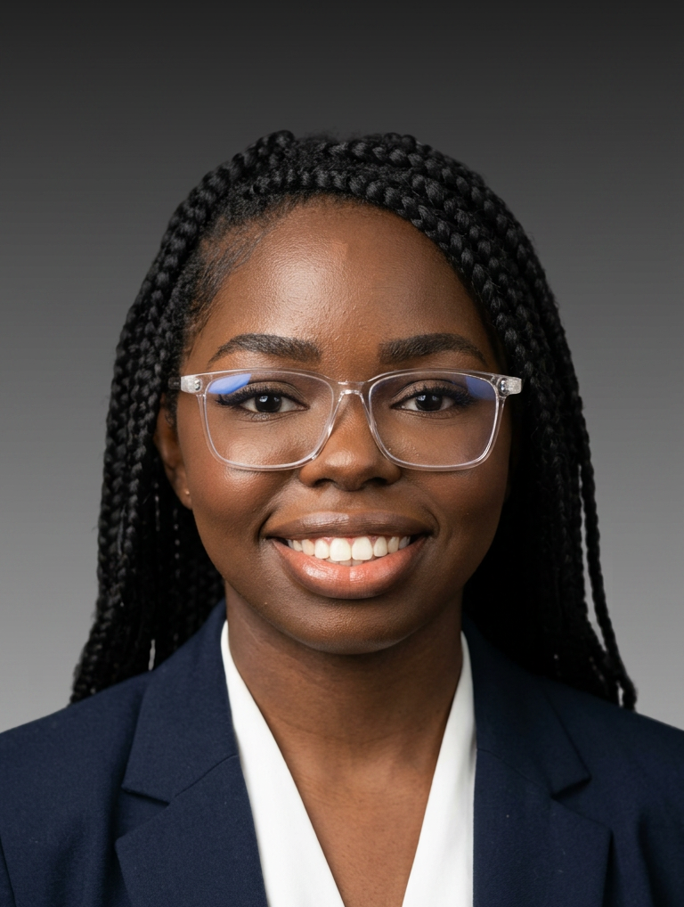Portrait of Adrianne Philpott, smiling  with braided hair and glasses, wearing a navy blazer on a gray background