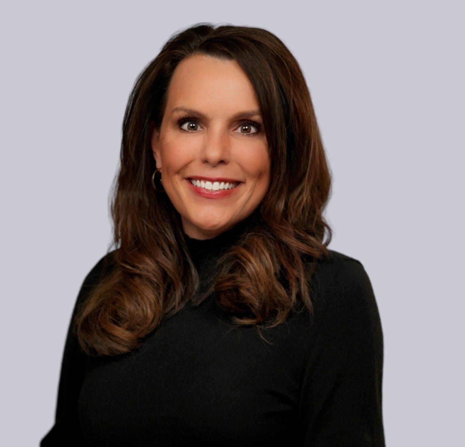 A woman wearing a black turtleneck is smiling for the camera