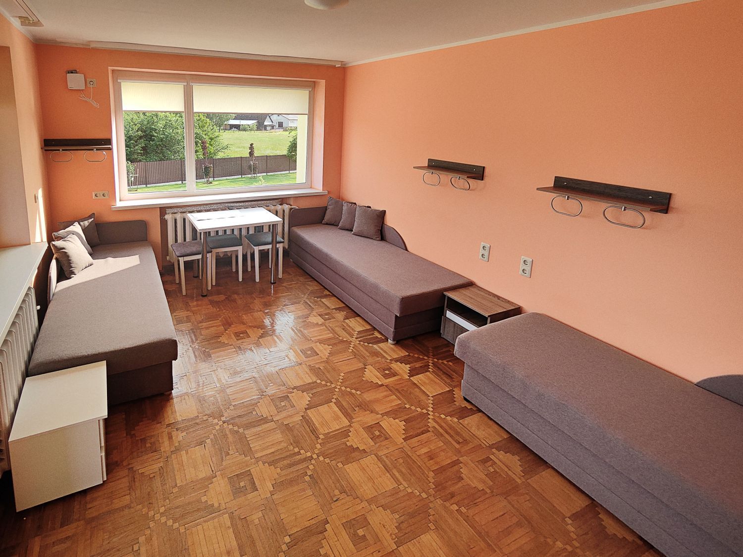 Svetainė su sofa, stalu ir kėdėmis.