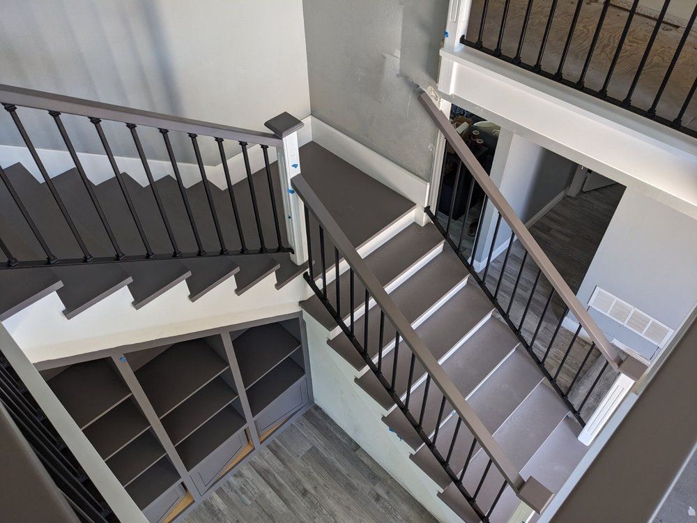Interior staircase with gray railings and white walls in a multi-level building