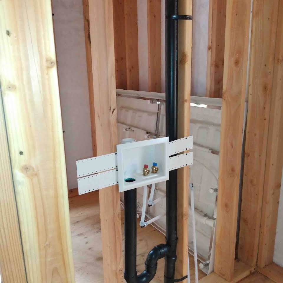 A wooden wall with pipes and a box in it