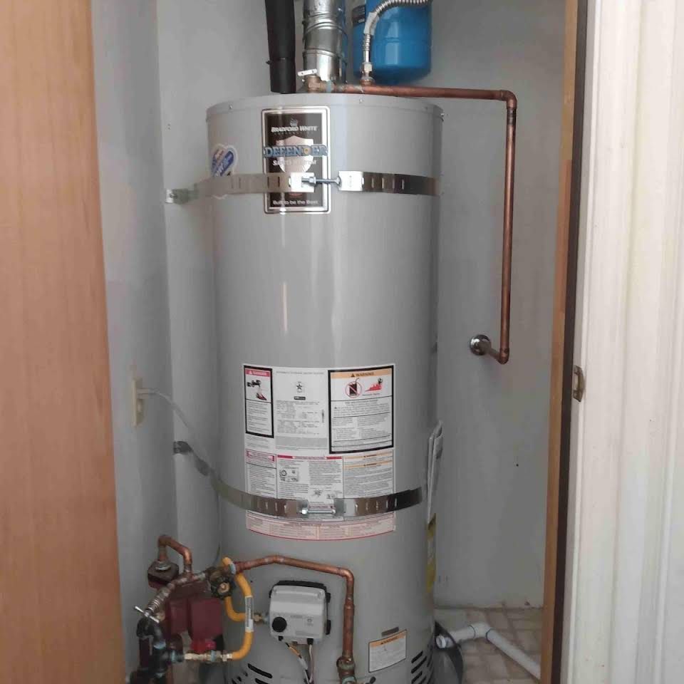 A water heater is sitting in a closet next to a door.