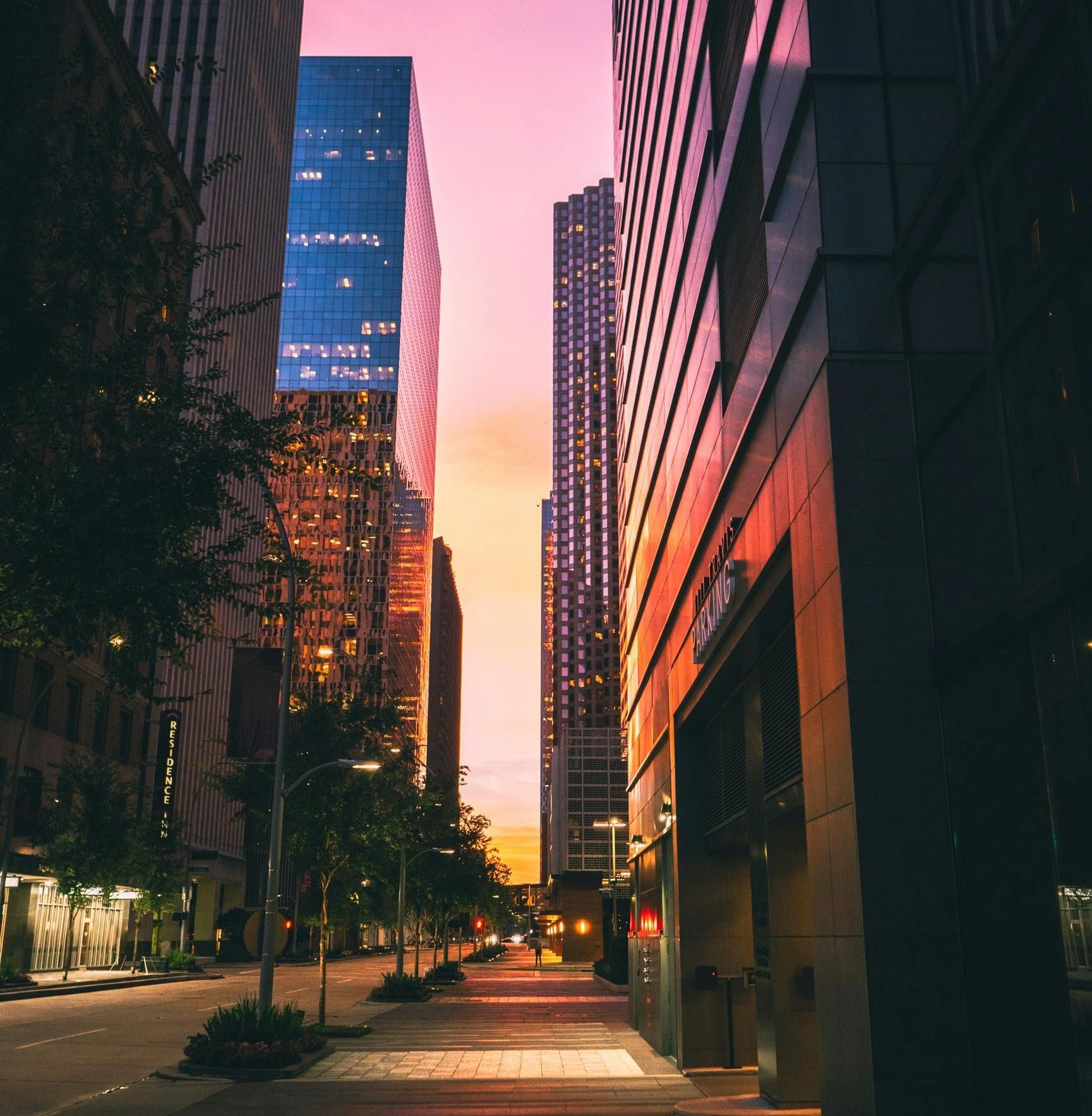 A city street with a sunset in the background