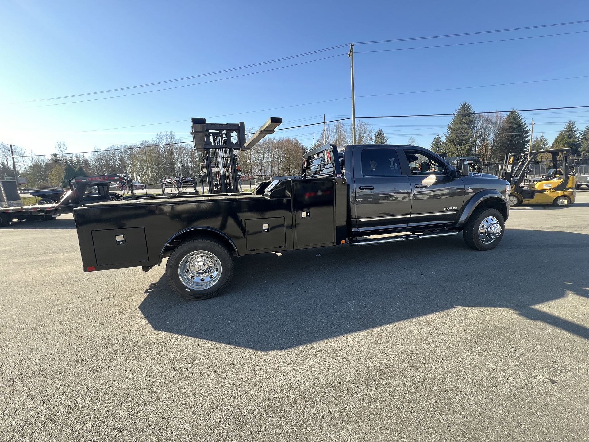 A Picture of Forklift and Black Pickup Truck Trailer at DBM Automotive in Pitt Meadows, BC
