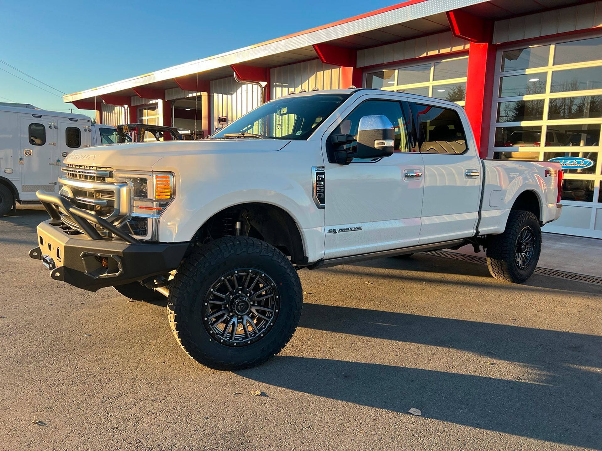 Picture of a White Truck Which is Parked in Front of DBM Automotive