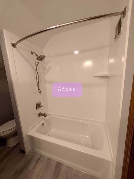 White bathtub and shower enclosure in bathroom, with chrome fixtures and a curved shower rod.