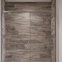 A shower with glass doors and gray tile walls.