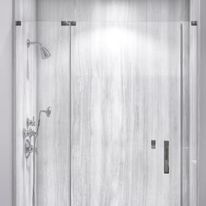 A modern, frameless glass shower with a white, textured wall. Chrome shower fixtures are visible.