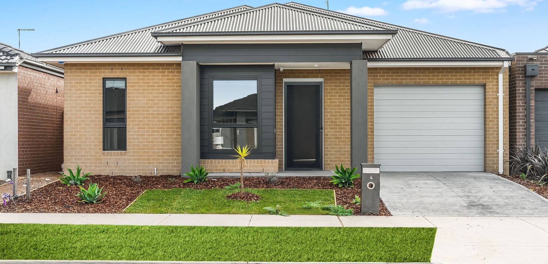 A brick house with a white garage door and a black door