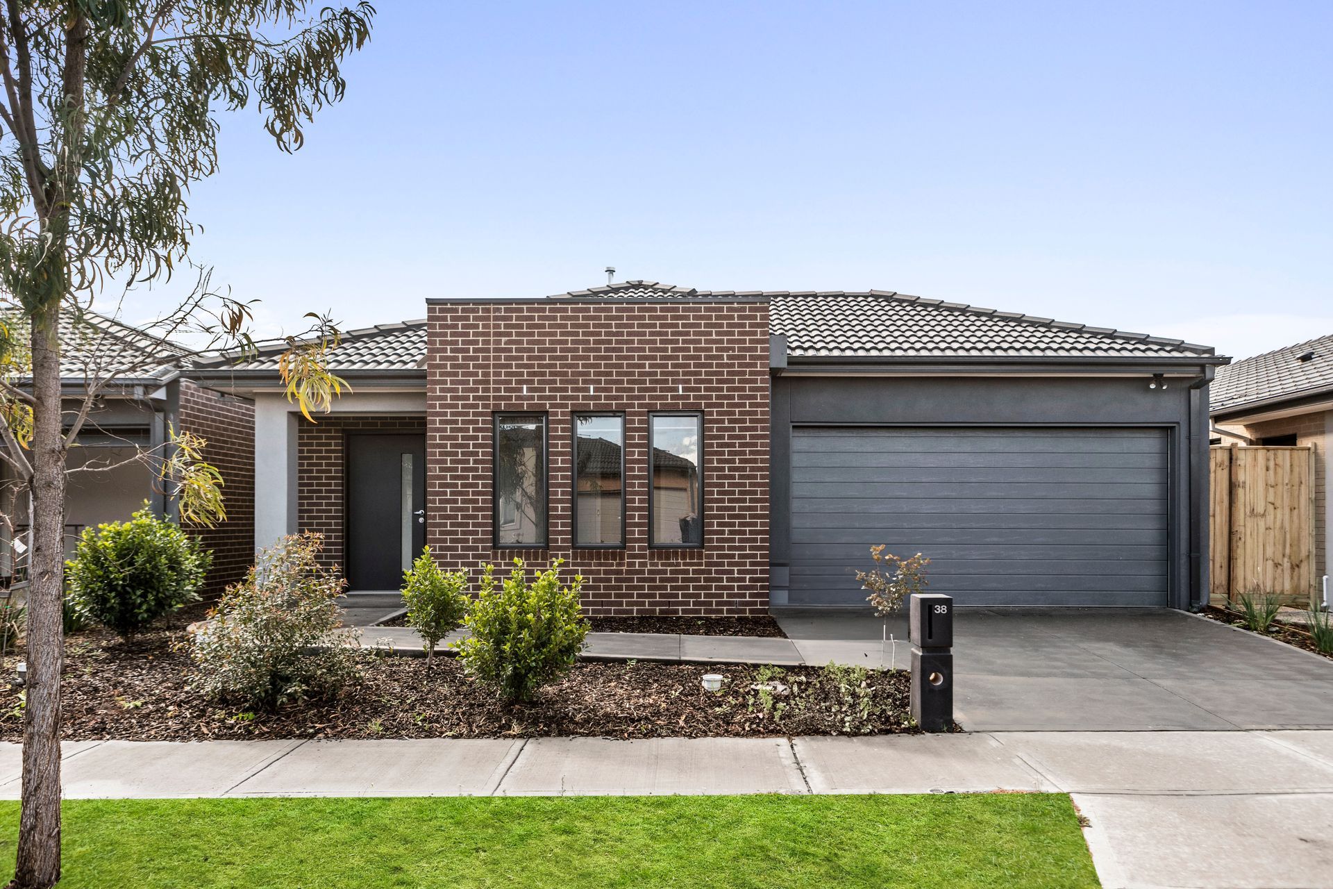 A house with a brick facade and a gray garage door