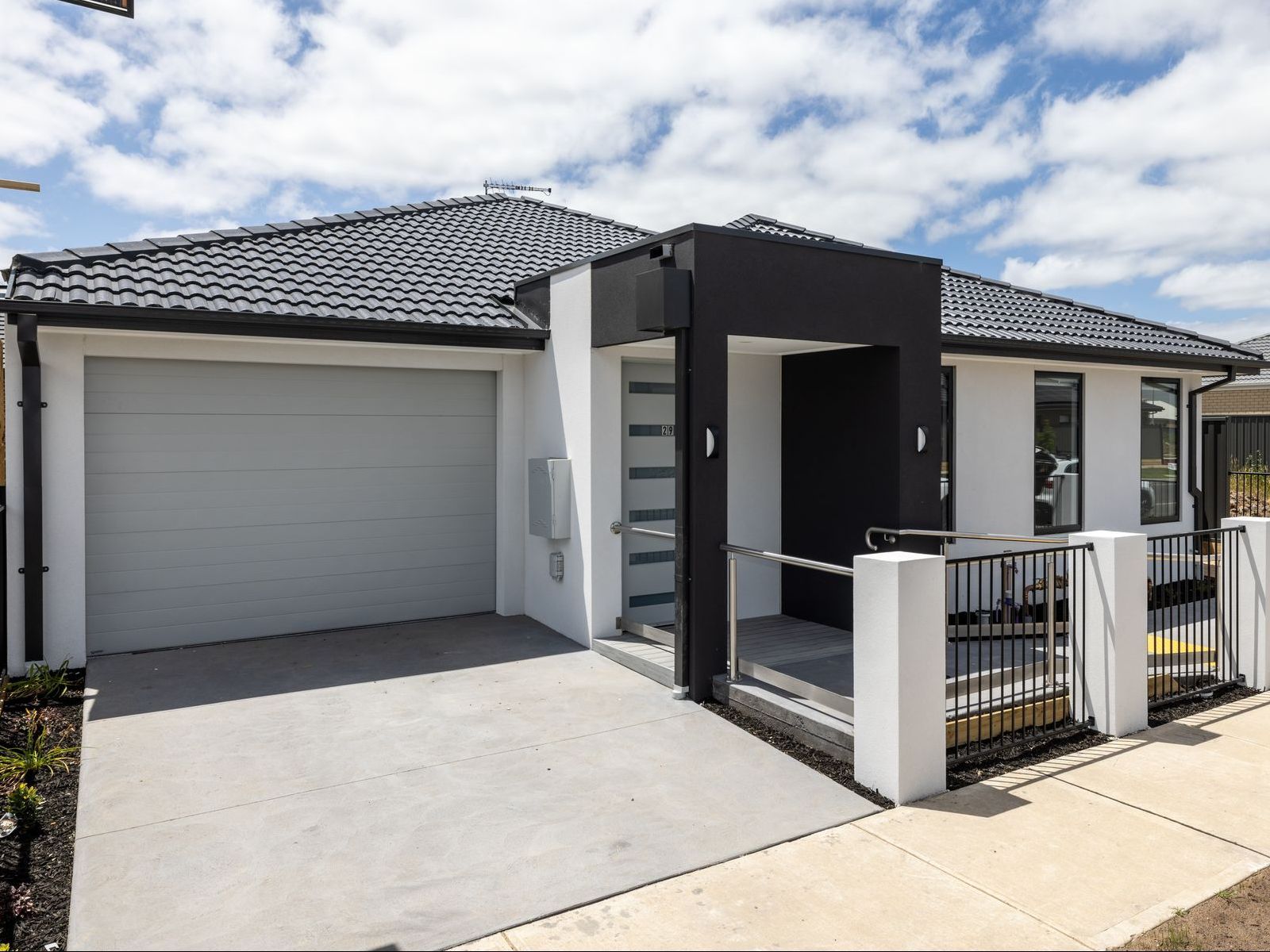 A house with a brick facade and a gray garage door