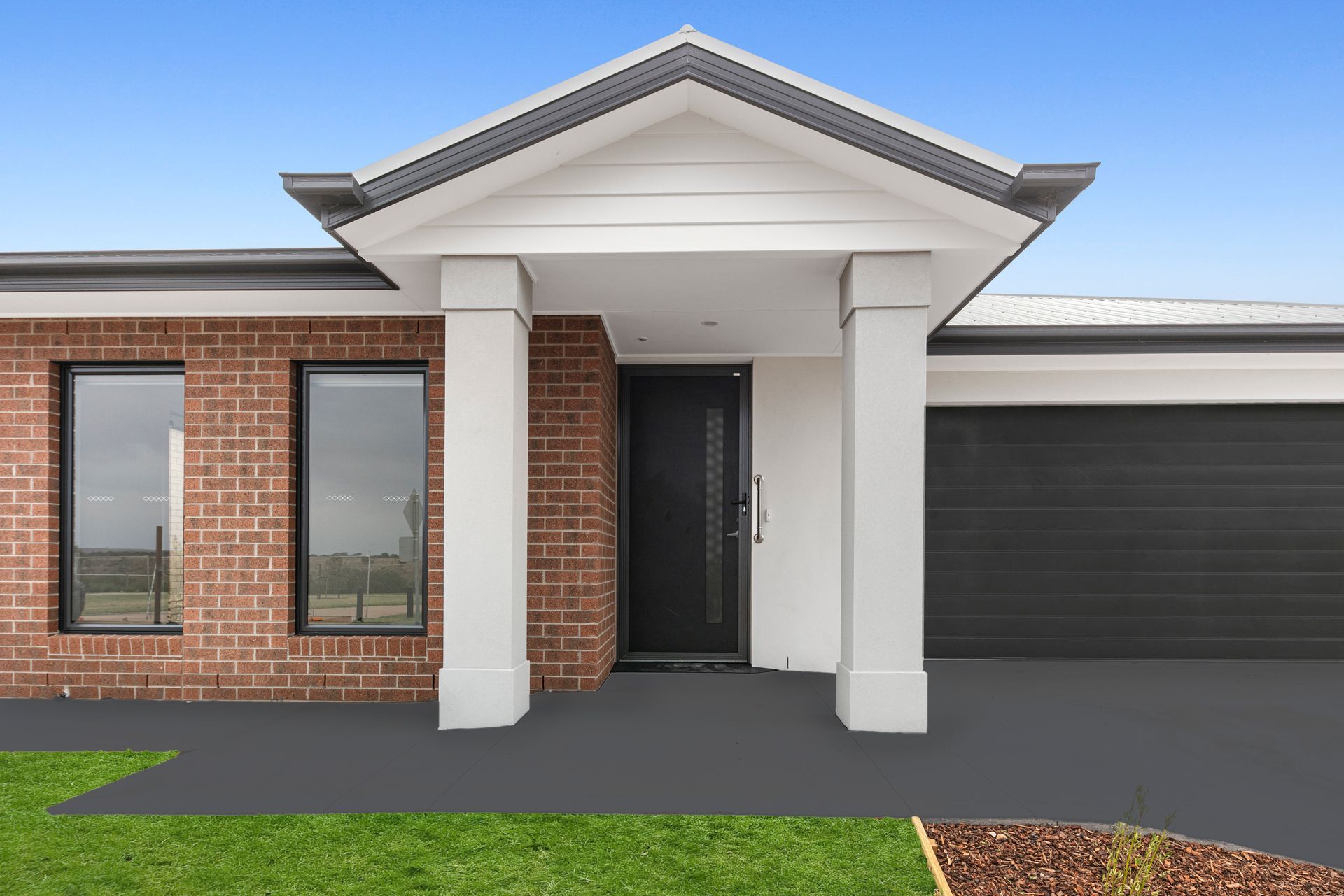 The front of a brick house with a porch and a garage.