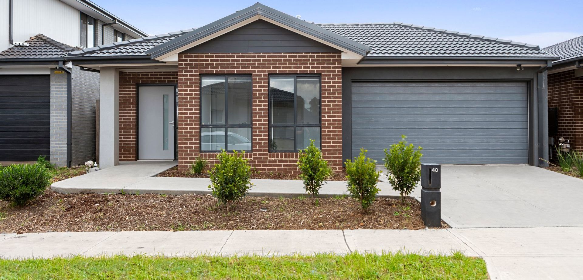 The front of a brick house with a garage and a driveway.