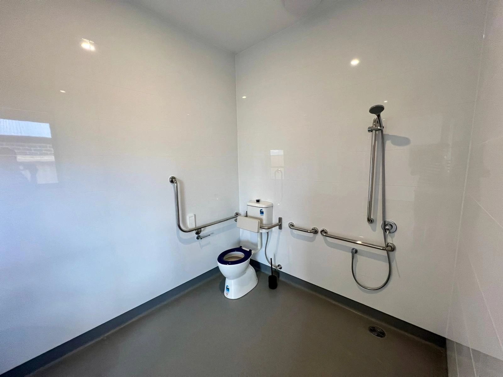 A bathroom with a toilet and a shower.