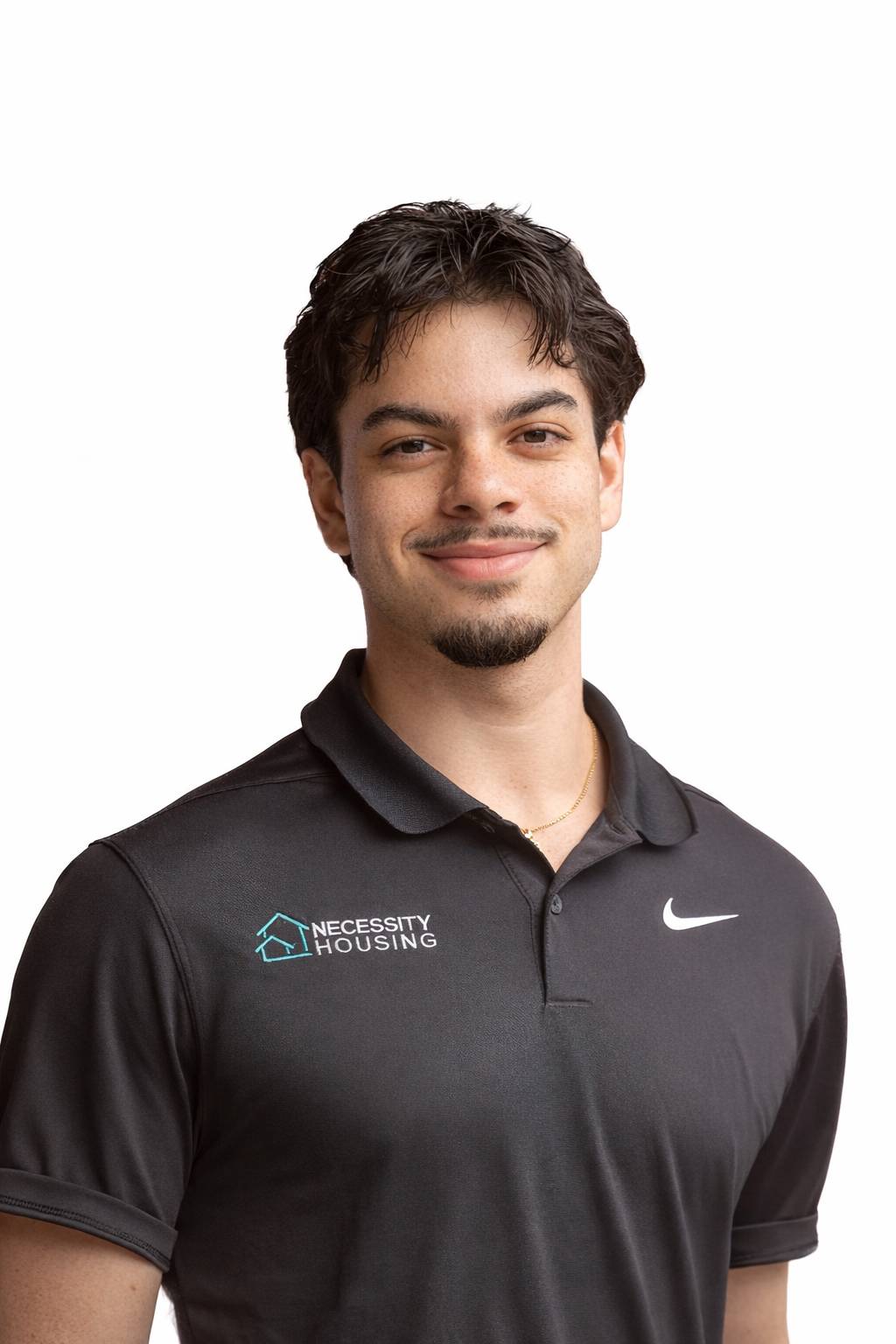 A young man wearing a white shirt and black tie is smiling