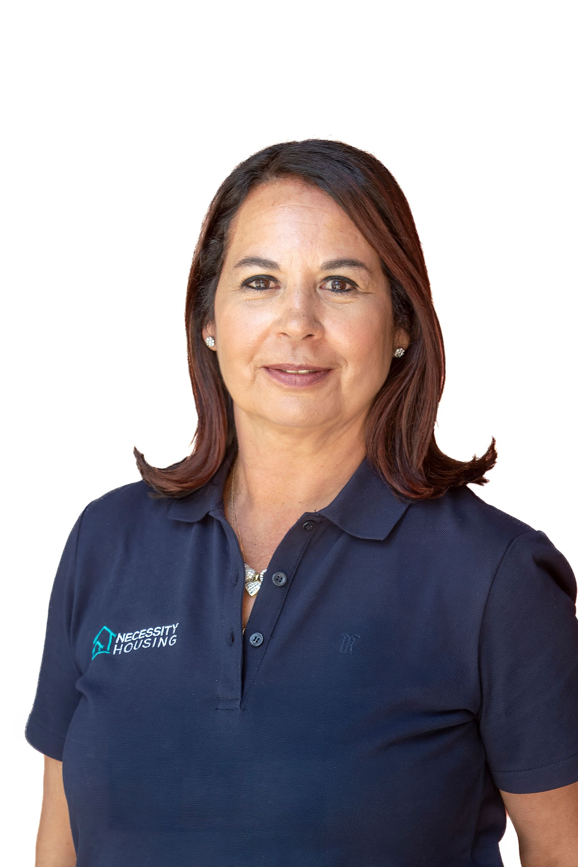 A woman wearing a blue shirt and a necklace smiles for the camera.