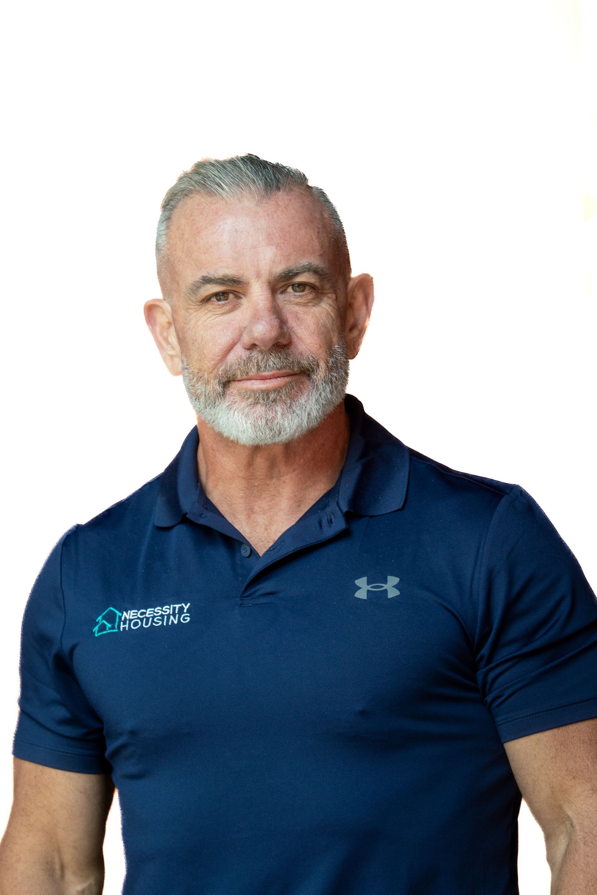 A man wearing a white shirt and black tie is smiling for the camera.