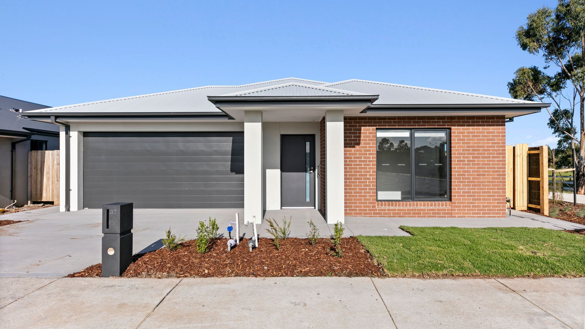 A car is parked in front of a house with a garage.