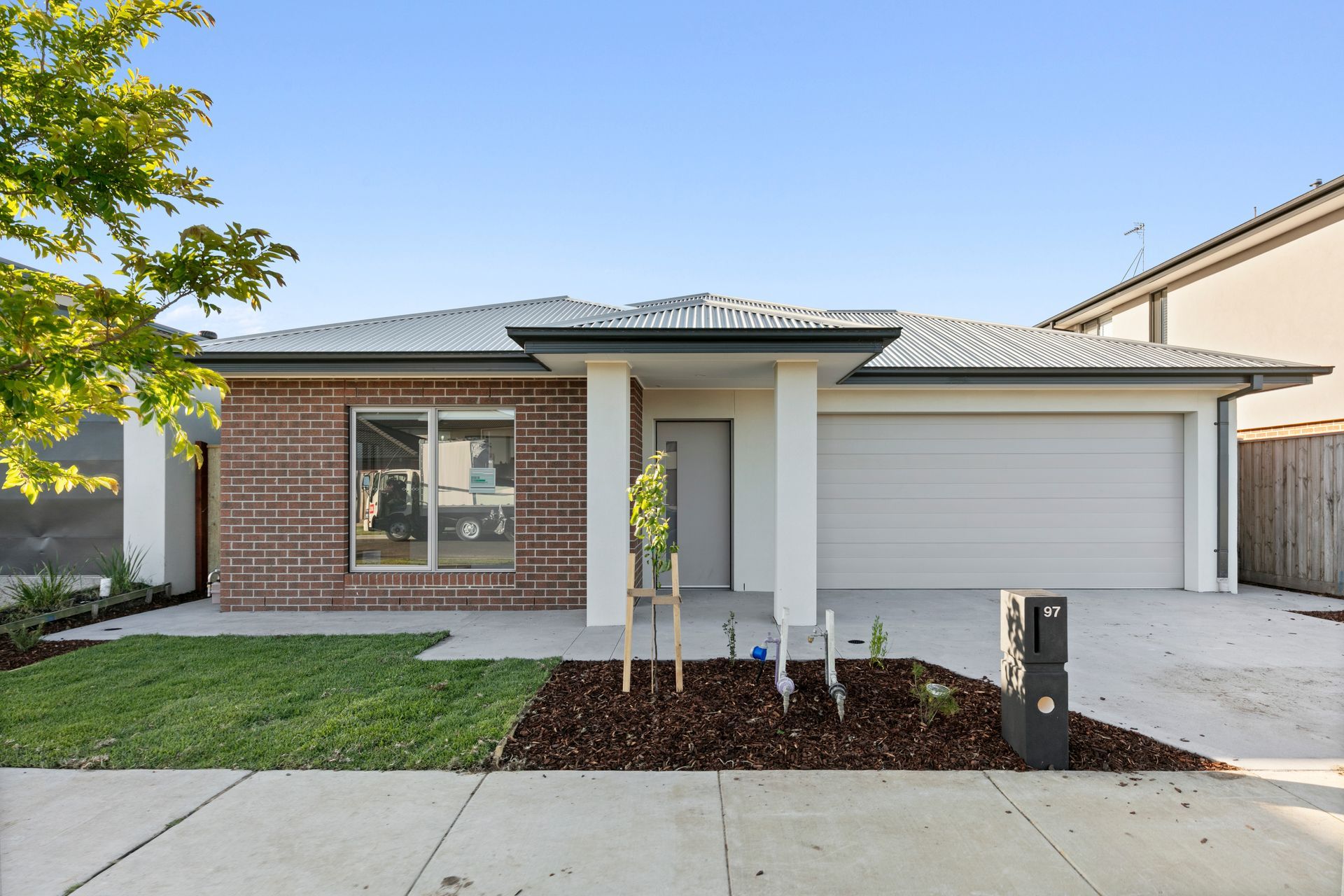 The front of a brick house with a black garage door.