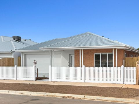 A house with a garage and a wooden fence in front of it.