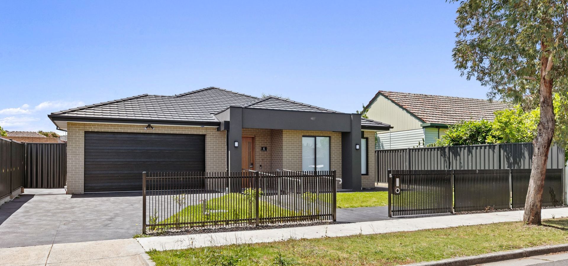 A car is parked in front of a house with a garage.