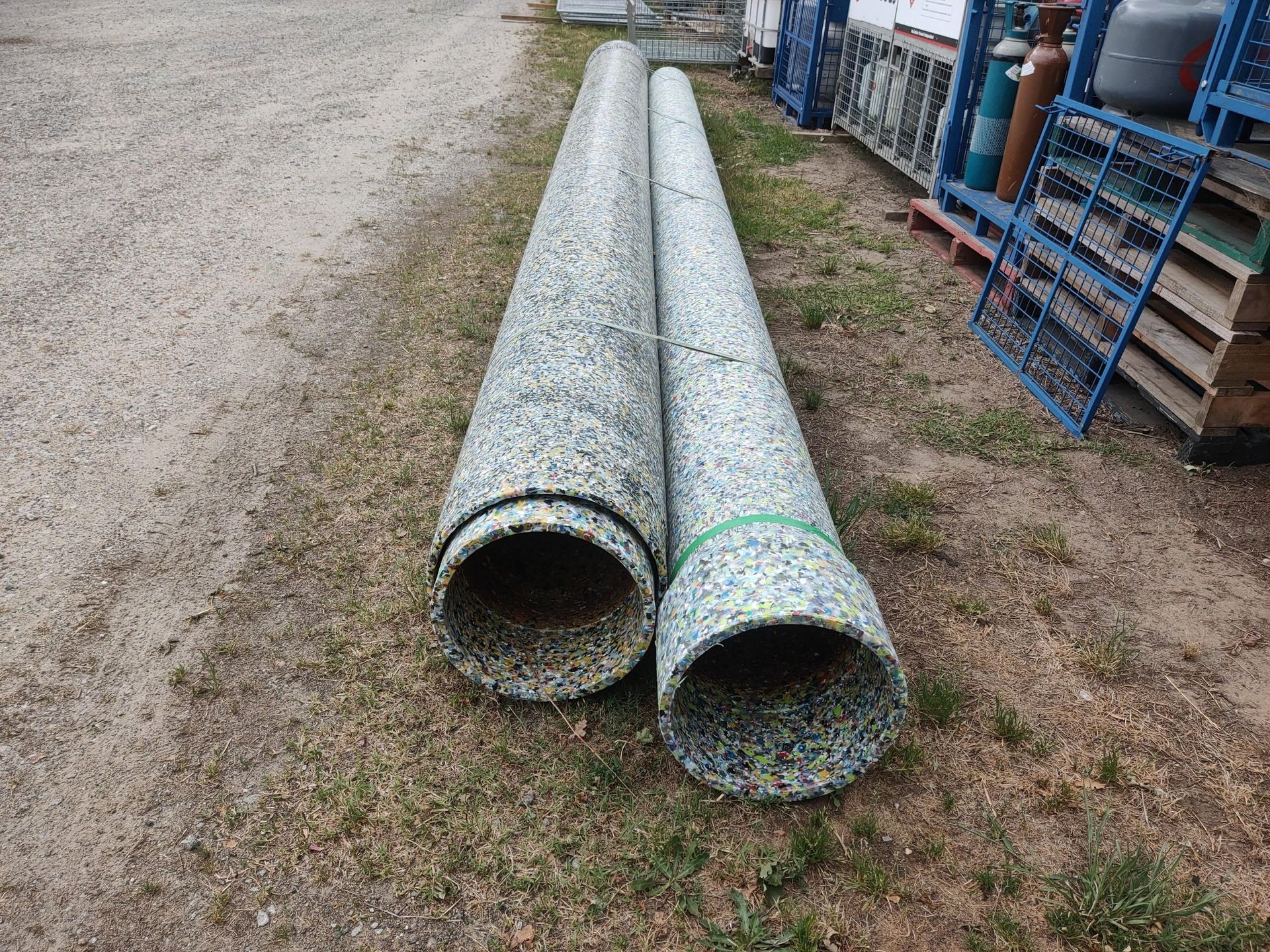 Two pipes are sitting on top of each other on the ground.