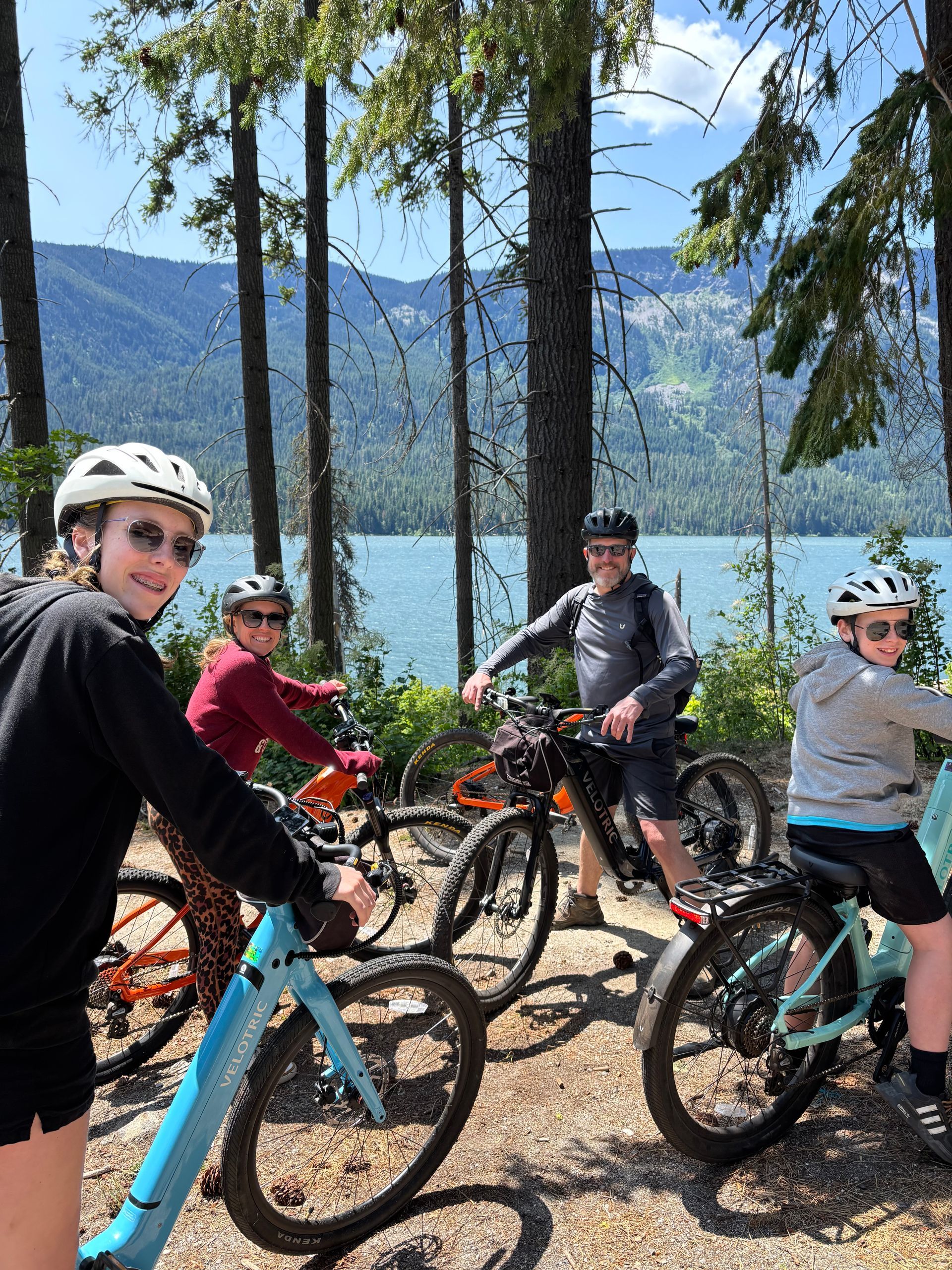 A group of people are riding bikes in the woods.