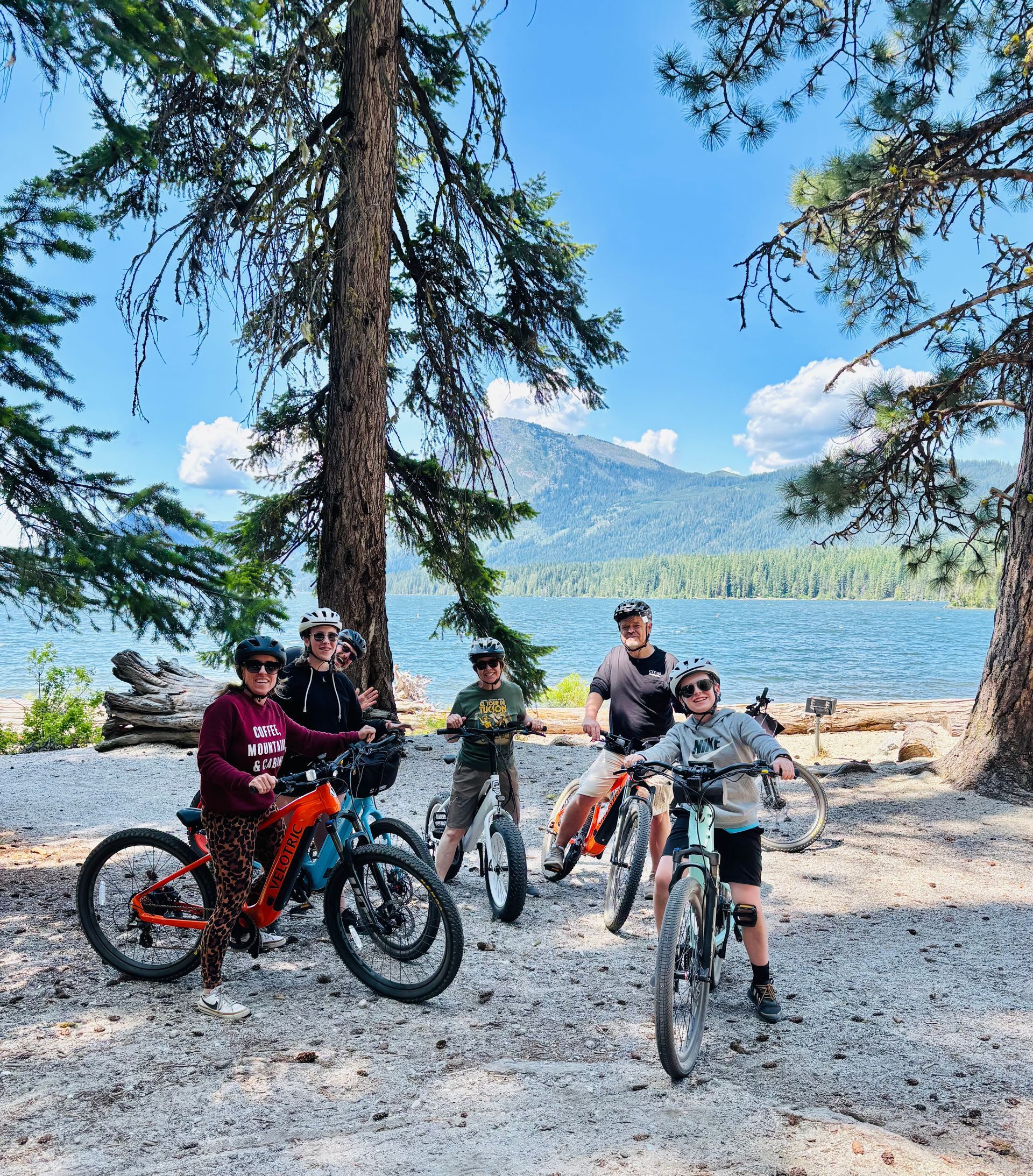 A group of people are standing next to each other on bicycles in the woods.