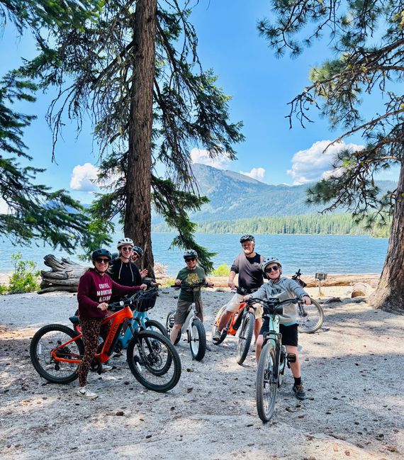 A group of people are standing next to each other on bicycles in the woods.