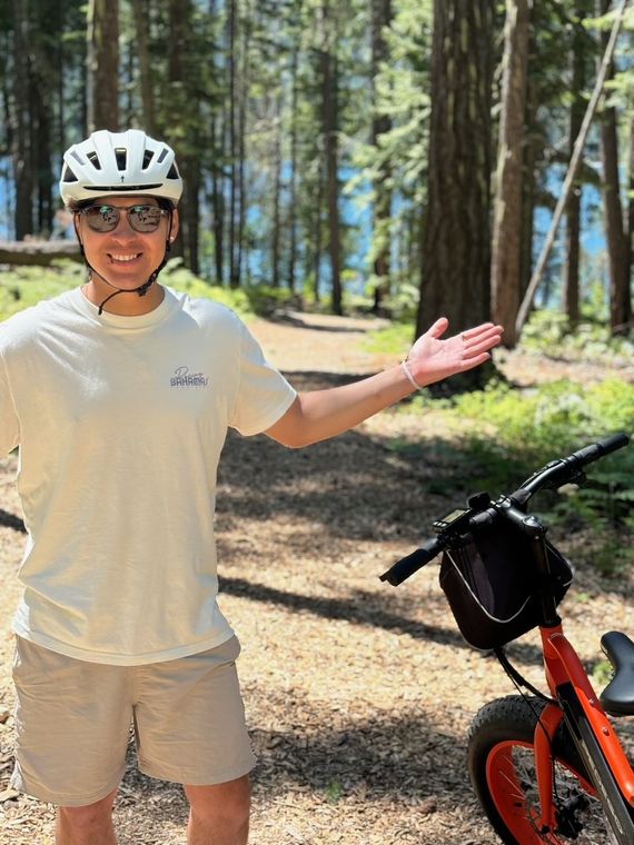 A man is riding a bike on a dirt road.