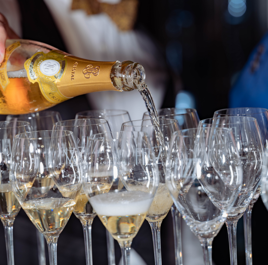 a man pouring a bottle of roederer cristal during an event at Fizz Sacramento.