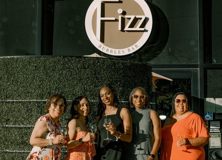 Ladies holding champagne at a private event.