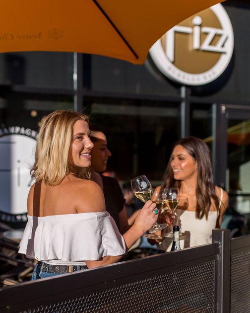 Women on the patio holding champagne glasses.