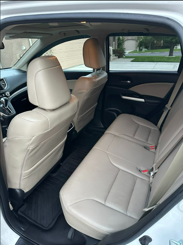 The back seat of a white car with tan leather seats