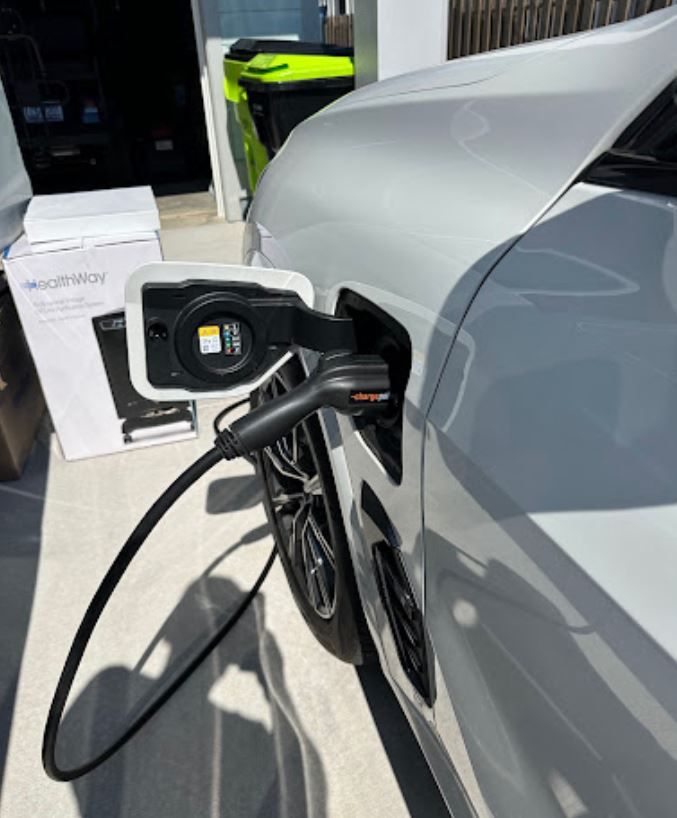 A silver car is plugged into a charging station