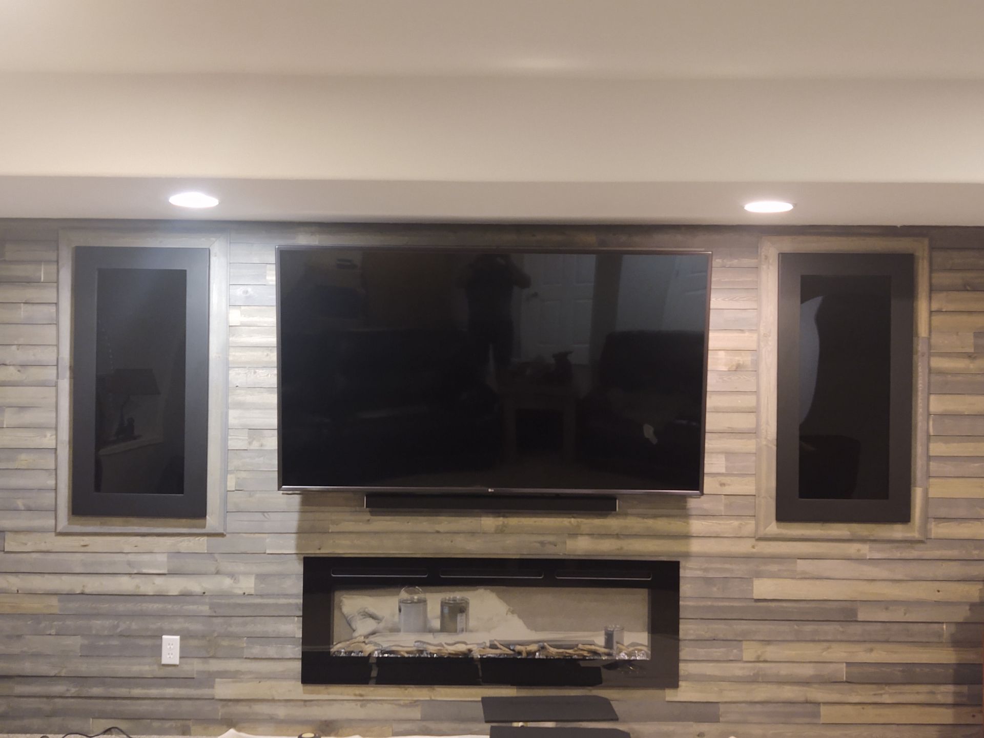 A living room with a fireplace and a flat screen tv on the wall.