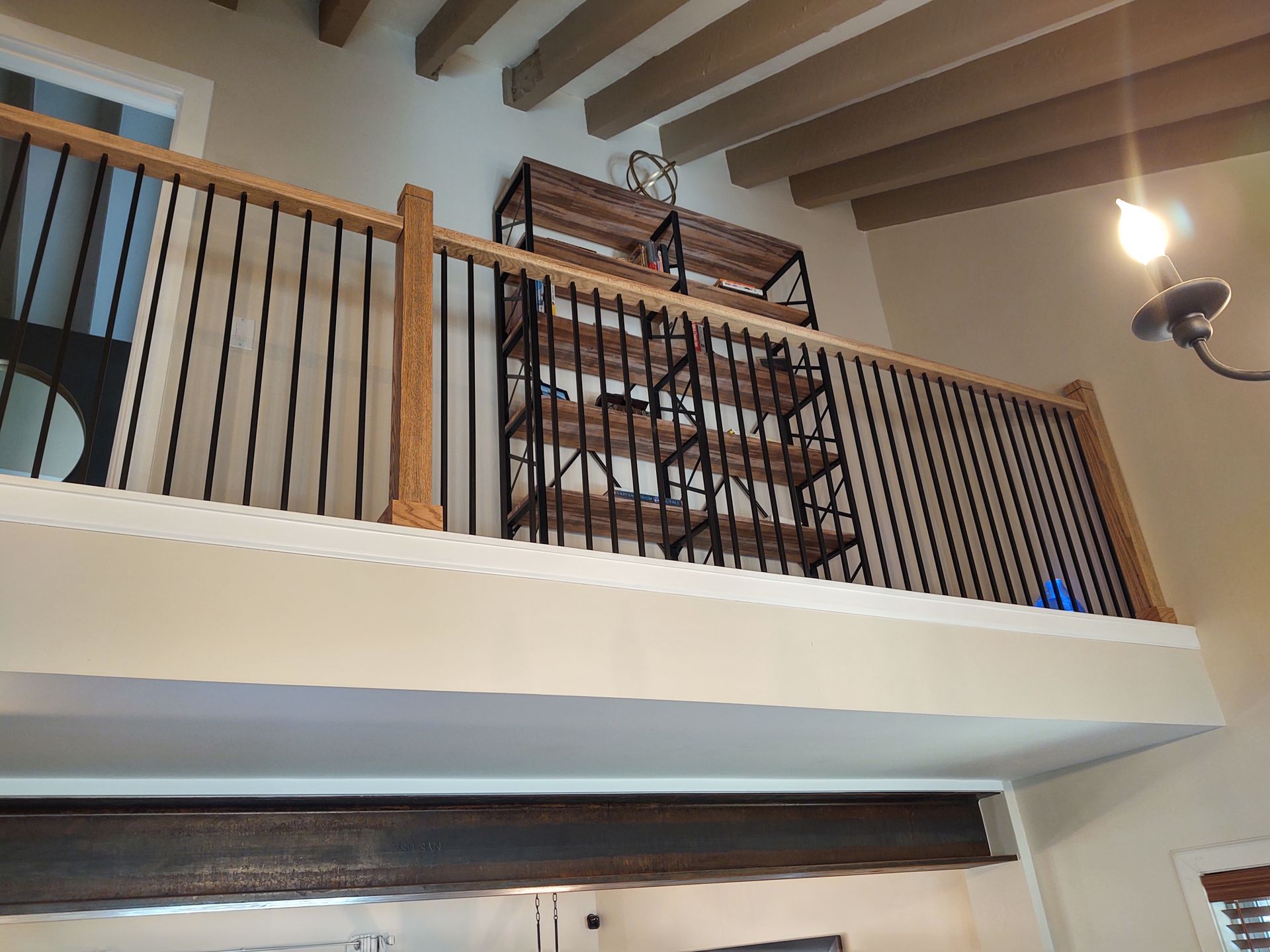 A balcony with a wooden railing and shelves in a kitchen.